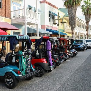 The Villages, Florida, USA - October 24, 2020: Golf carts parked downtown at Market Square in Sumpter Landing. The Villages is a popular retirement golf cart loving community.